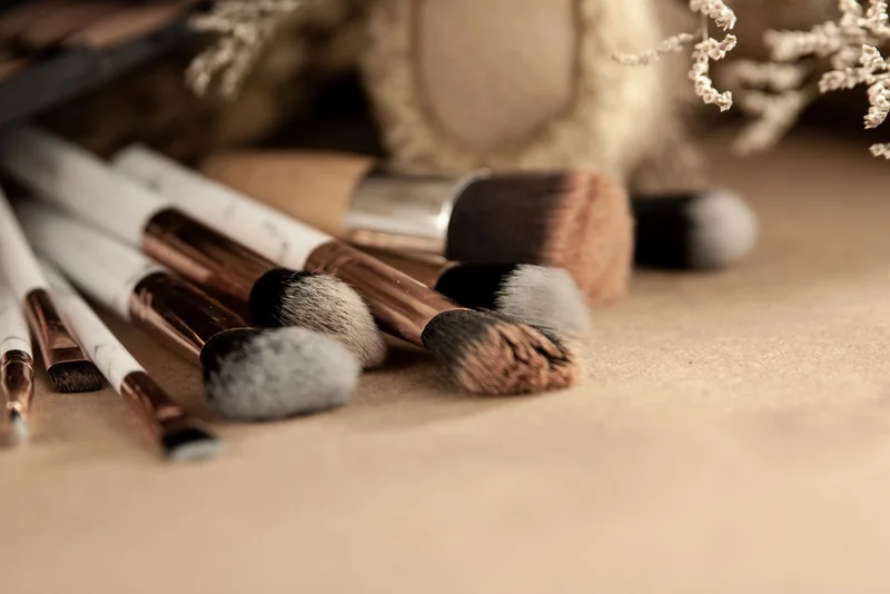 Makeup brushes on a warm neutral surface